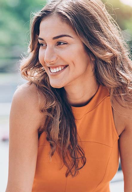 Brown haired woman smiling and looking right.