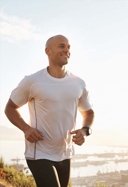 Man smiling and running along the marina